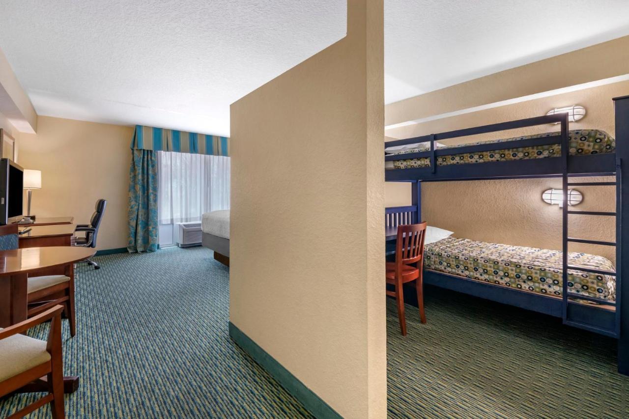 Suite met kingsize bed, 2 stapelbedden en uitzicht op het zwembad