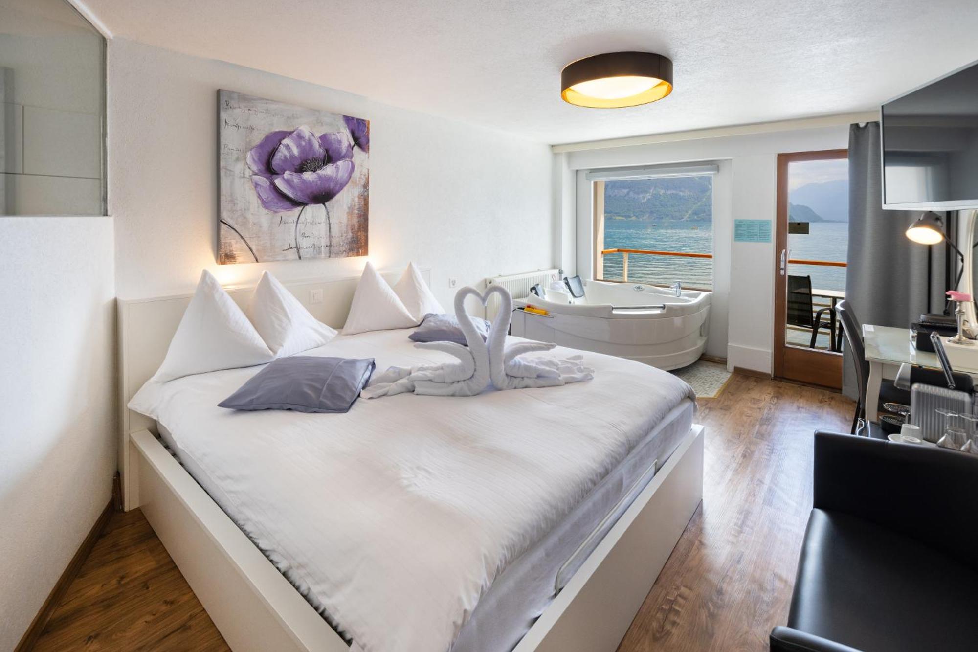 Zimmer mit Queensize-Bett, rollendem Whirlpool und Seeblick