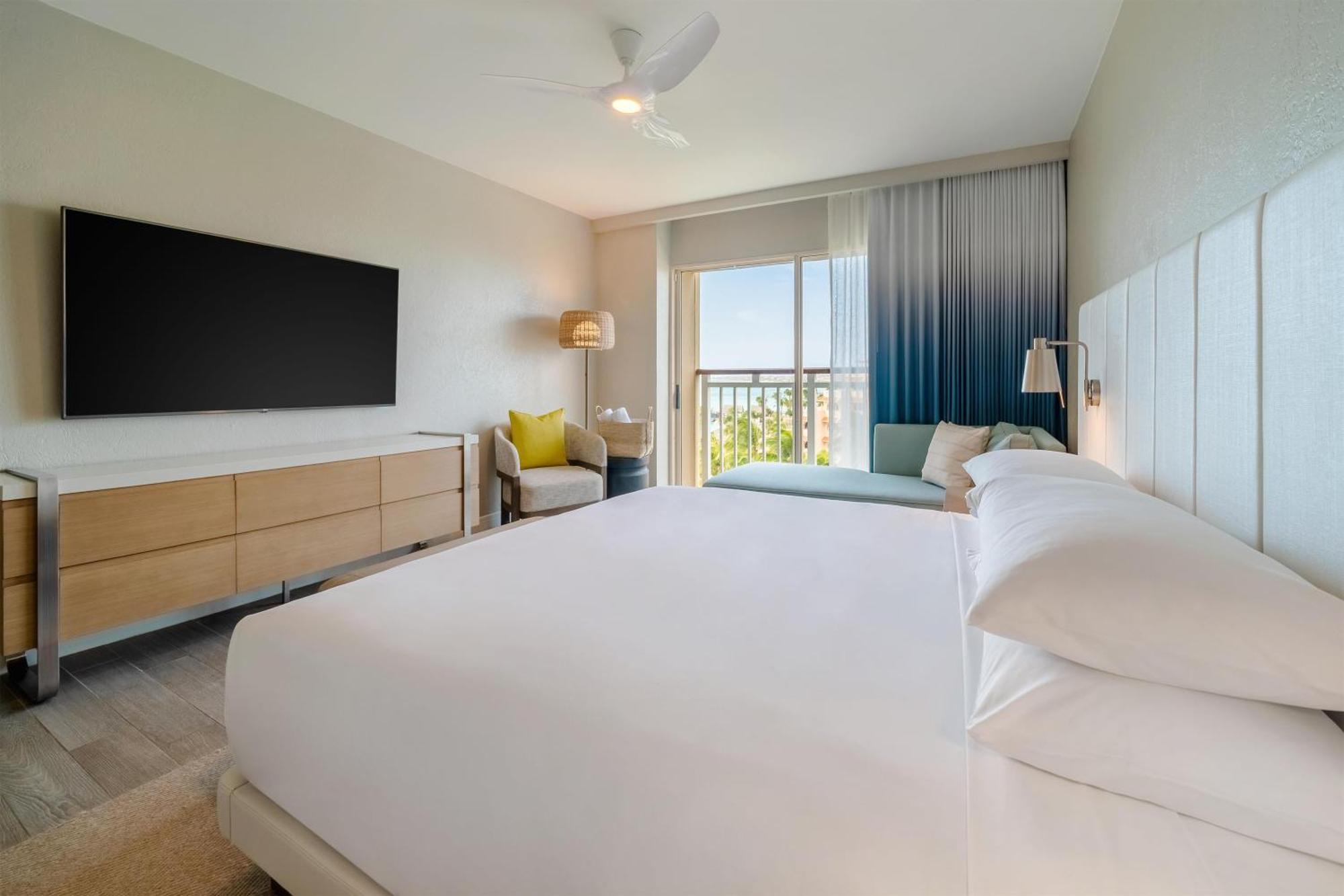 Zimmer mit Kingsize-Bett sowie Blick auf das Resort und das Meer